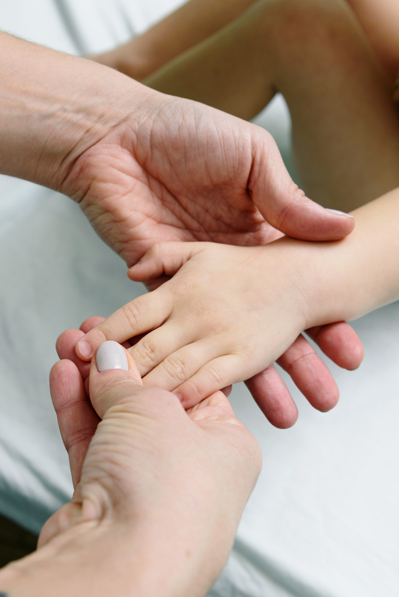 Close-Up Shot of Person Touching a Child's Hand